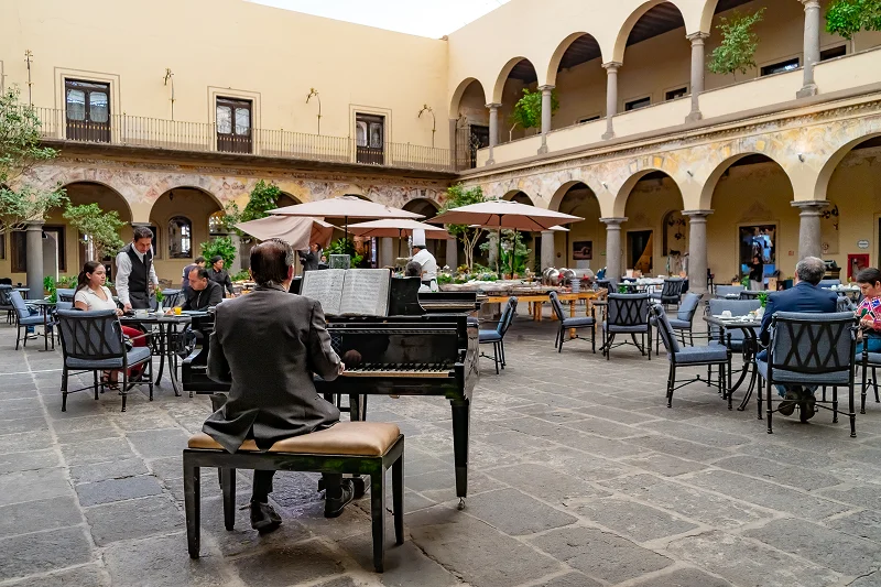 Pianista tocando en patio con personas comiendo en Puenla